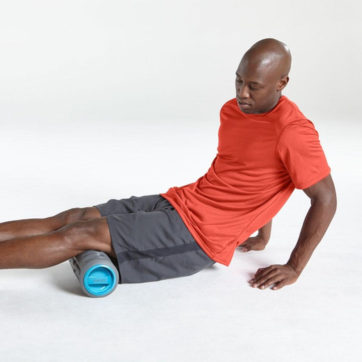 Man stretches legs out on the Homedics Gladiator Vibration Foam Roller