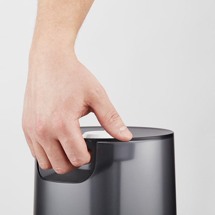 Man carries Homedics TotalComfort Adjustable Mist Ultrasonic Humidifier by tank handle