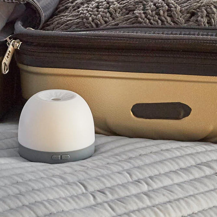 Homedics Personal Portable Aroma Pad Diffuser next to luggage