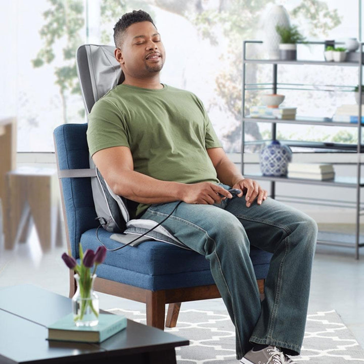 Man relaxes in chair while enjoying a massage from the Homedics Gentle Touch Gel Deluxe Shiatsu Massage Cushion with Soothing Heat