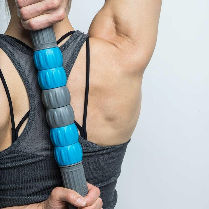 Woman holds Homedics Vertex Vibration Stick Roller against back