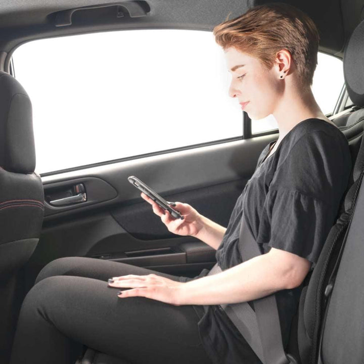Woman in back seat of car sits on the Homedics Mobile Comfort Perfect Temp Travel Cushion