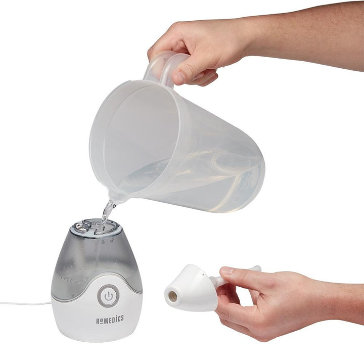 Hands fill the Homedics TotalComfort Personal Ultrasonic Humidifier tank with water