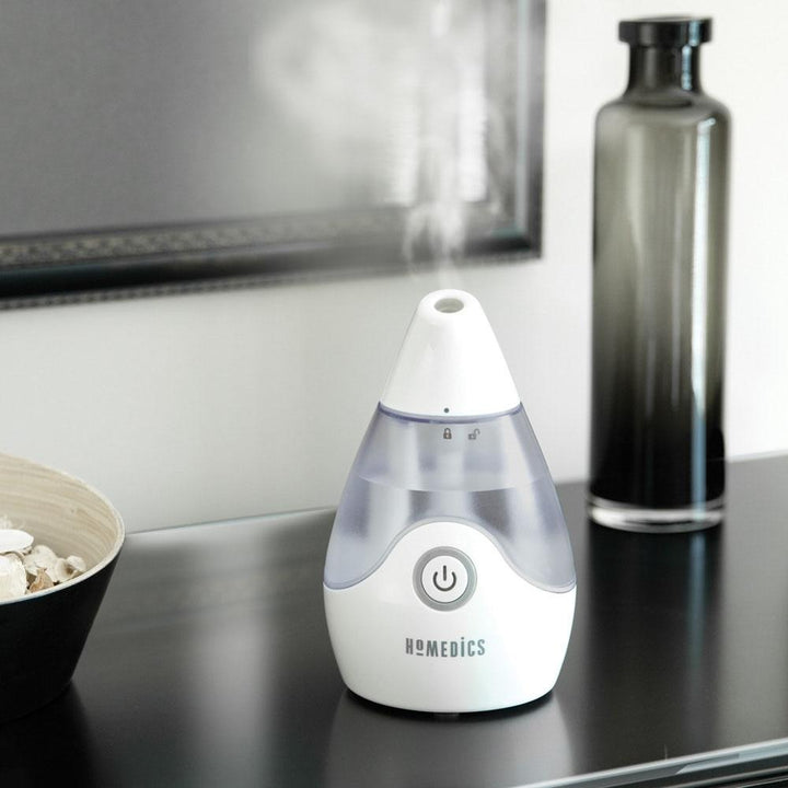 Homedics TotalComfort Personal Ultrasonic Humidifier powered on sitting on table