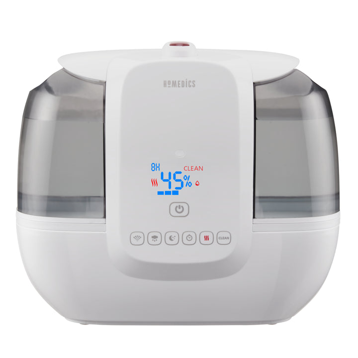 A woman pours water from the top of the TotalComfort® Ultrasonic Humidifier with UV-C Technology and Remote Control