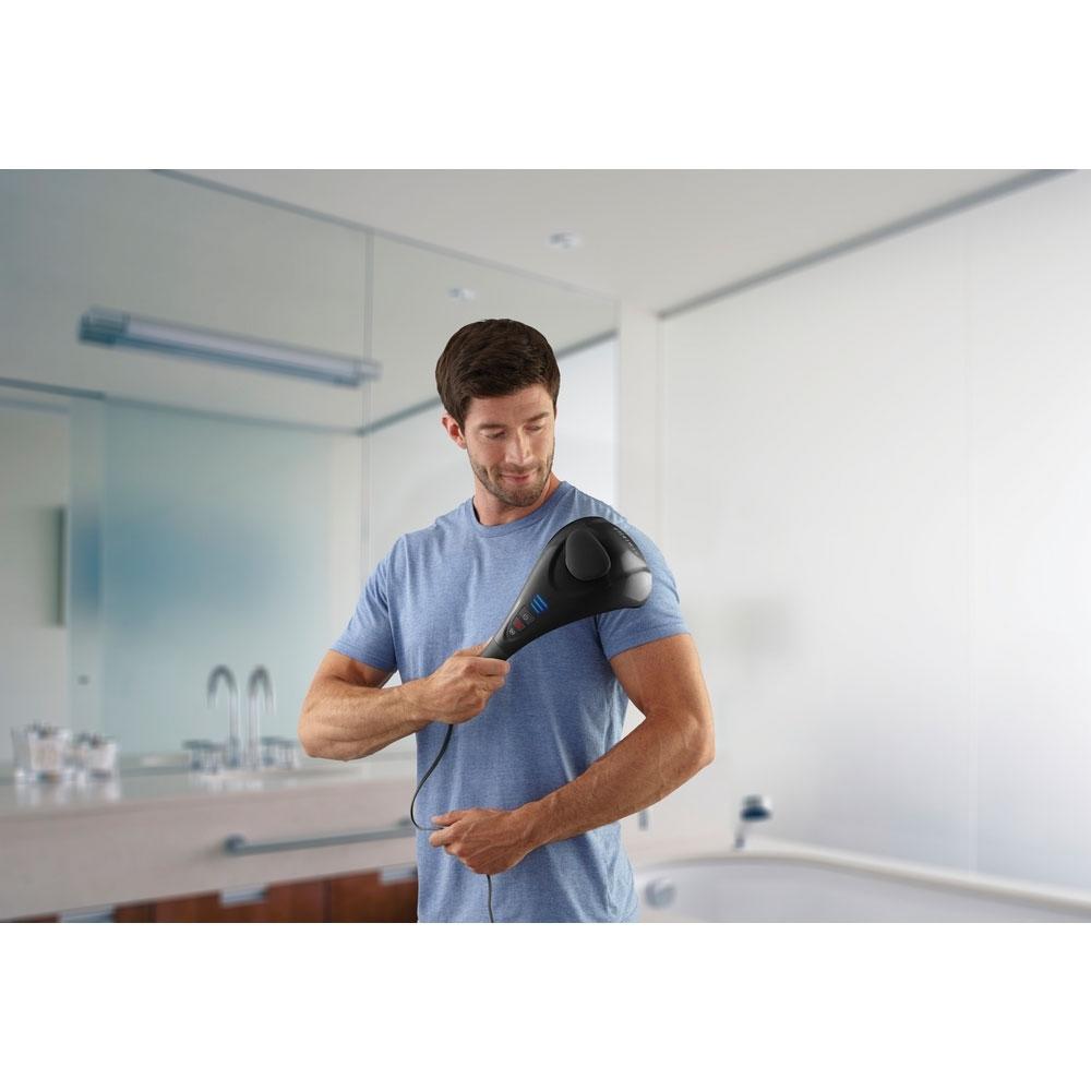 Standing man holds Homedics Twin Percussion Pro Massager with Heat to left shoulder