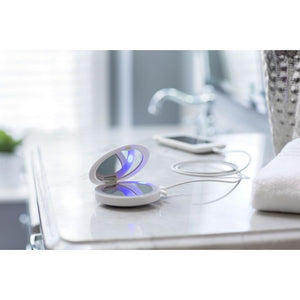 Angled view of open Homedics Compact Charging LED Mirror with Rechargeable Light sitting on table