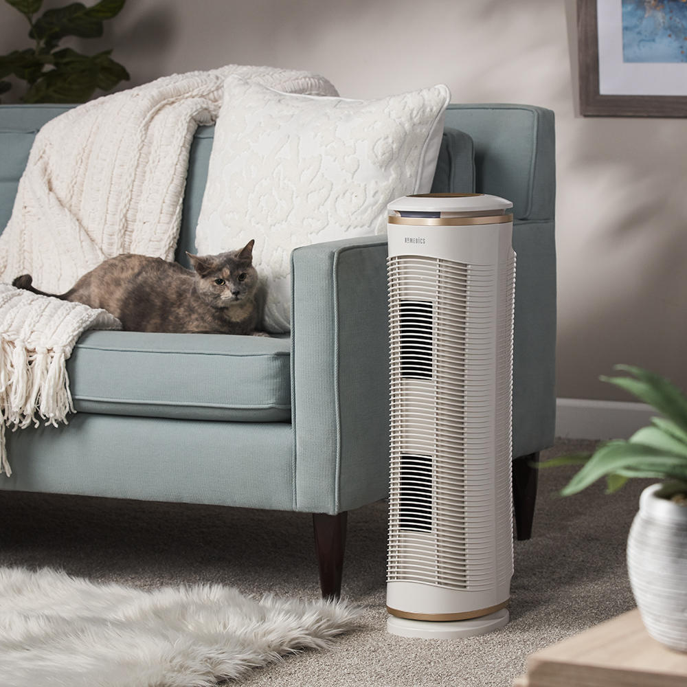 Homedics TotalClean PetPlus Air Purifier on the floor next to sofa with cat