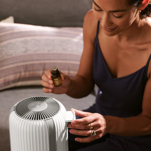 Woman loads essential oils into the TotalClean® HEPA Small Room Air Purifier