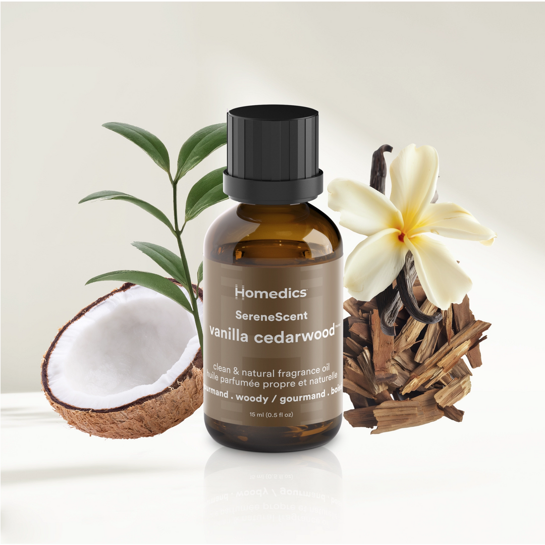 SereneScent™ Vanilla Cedarwood fragrance oil bottle with coconut, flowers, and wood elements on a light background