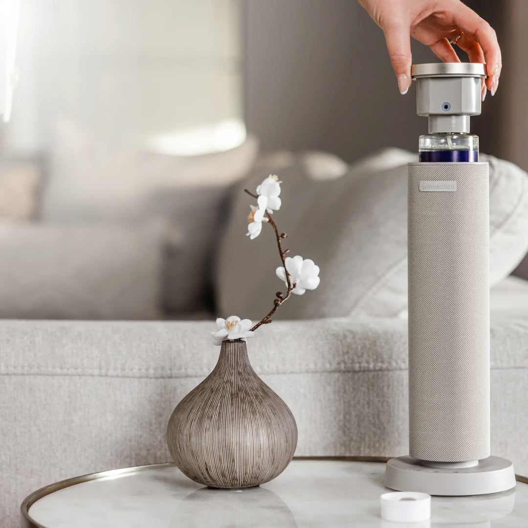 SereneScent™ waterless diffuser on a table with a vase and flowers in the background