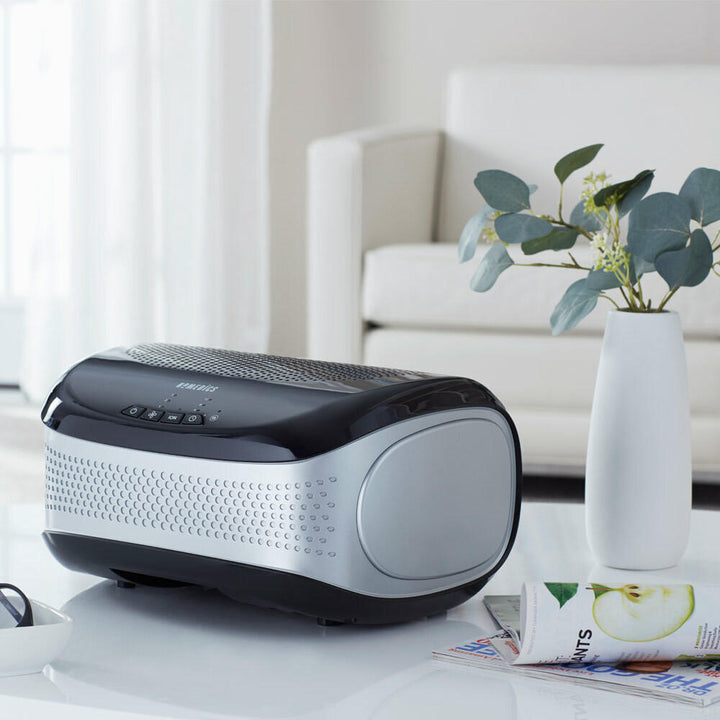 Black | Black Homedics TotalClean Desktop Air Purifier on table next to plant