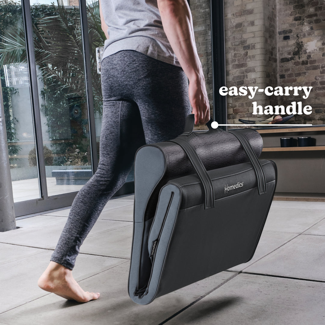 Woman carries folded Homedics Body Flex Back Stretching Mat with Heat