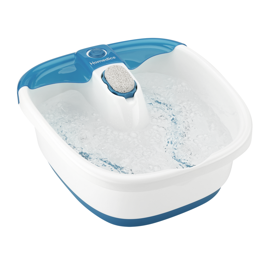 Woman sits on the end of the bathtub with feet in the Homedics Bubble Mate Foot Spa with Heat