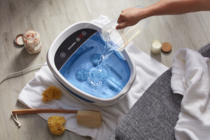 Lifestyle view of person pouring water into the Shiatsu Bliss Foot Spa with Heat Boost