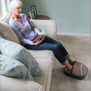 Woman sitting on couch using the Air Compression Shiatsu Foot Massager