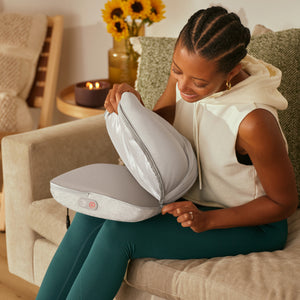 A woman unzips the Homedics® 3-in-1 Shiatsu Massager