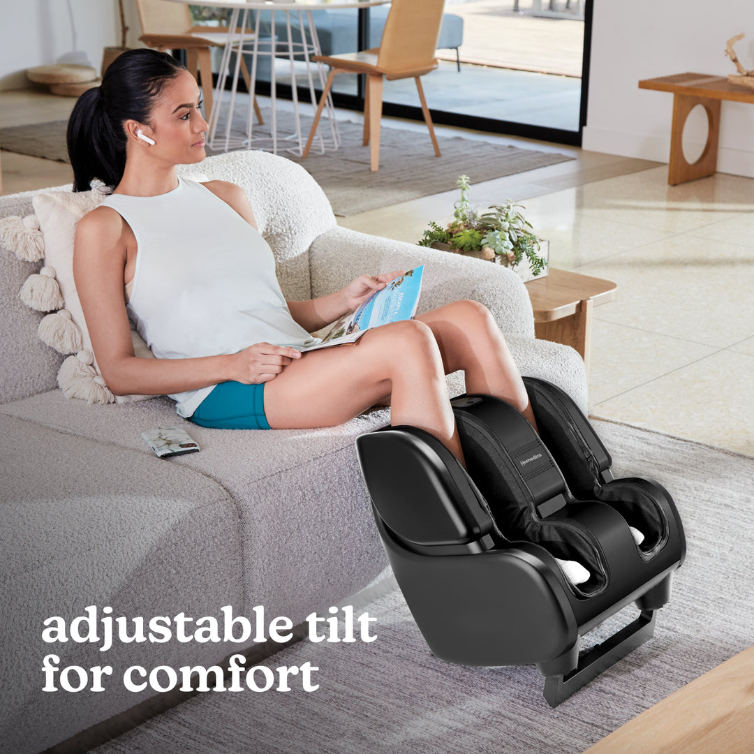Woman sits on couch while enjoying a massage from the Homedics Therapist Select Foot and Calf Massager