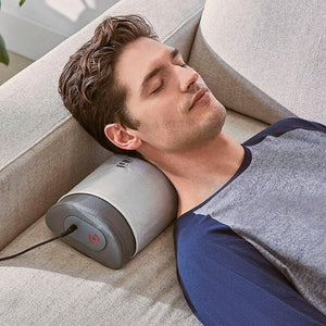 Man stretched out on couch relaxes on the Homedics Lumbar Pillow with Soothing Heat