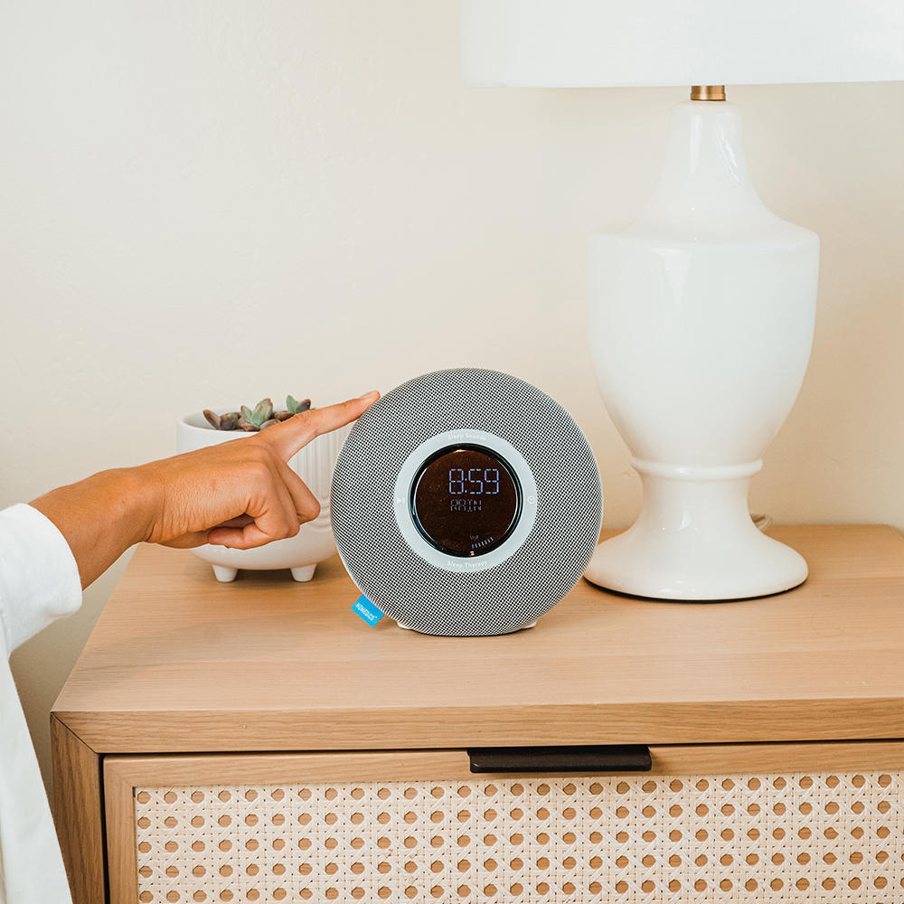 Homedics Deep Sleep Revitalize Engineered Sleep Sound Alarm Clock on night stand next to lamp