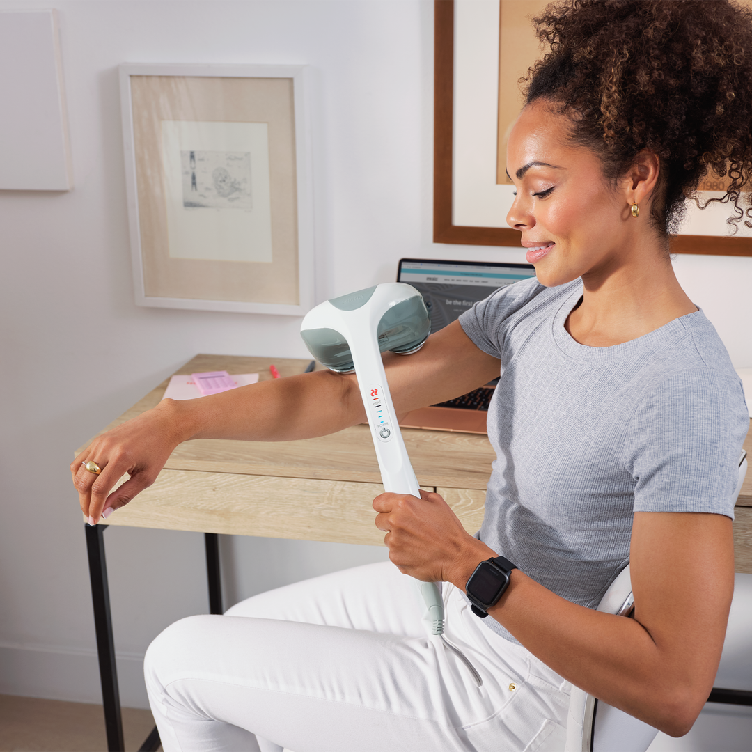 White | Woman massages right arm with white Percussion Action Plus Handheld Massager with Heat