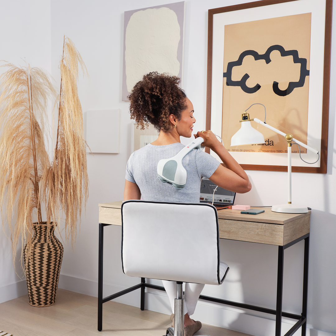 White | Back angle view of woman massaging back with the Percussion Action Plus Handheld Massager with Heat