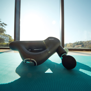 Angled view of the Homedics Therapist Select DuoTemp Pro Percussion Massager with sunlight in the background