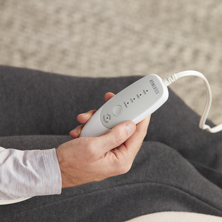 Close-up view of man holding the analog controller for the Homedics 12" x 15" Heating Pad with Removable Cover