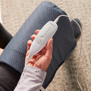 Close-up of man holding analog LCD controller for the Homedics 12