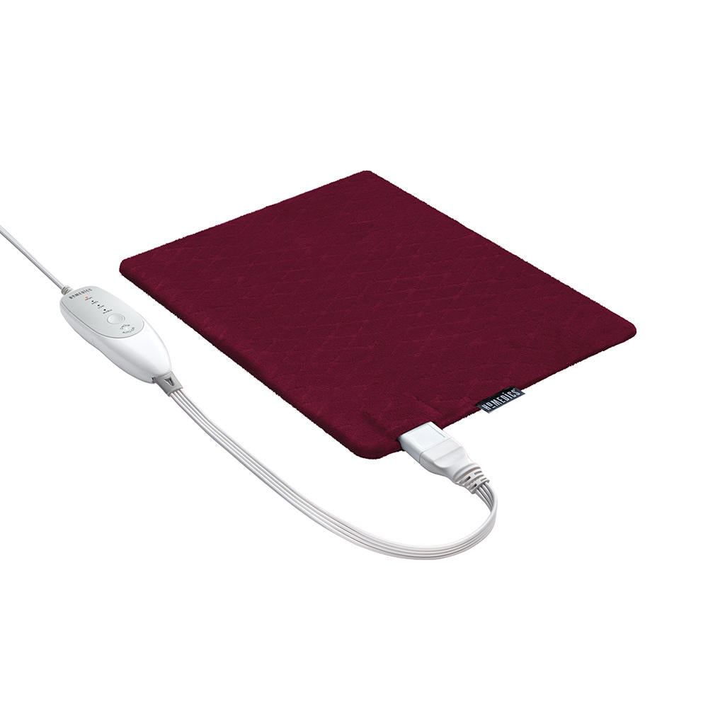 Woman sits on couch with the Homedics 12" x 15" Weighted Heating Pad with Humiditech spread on her right shoulder