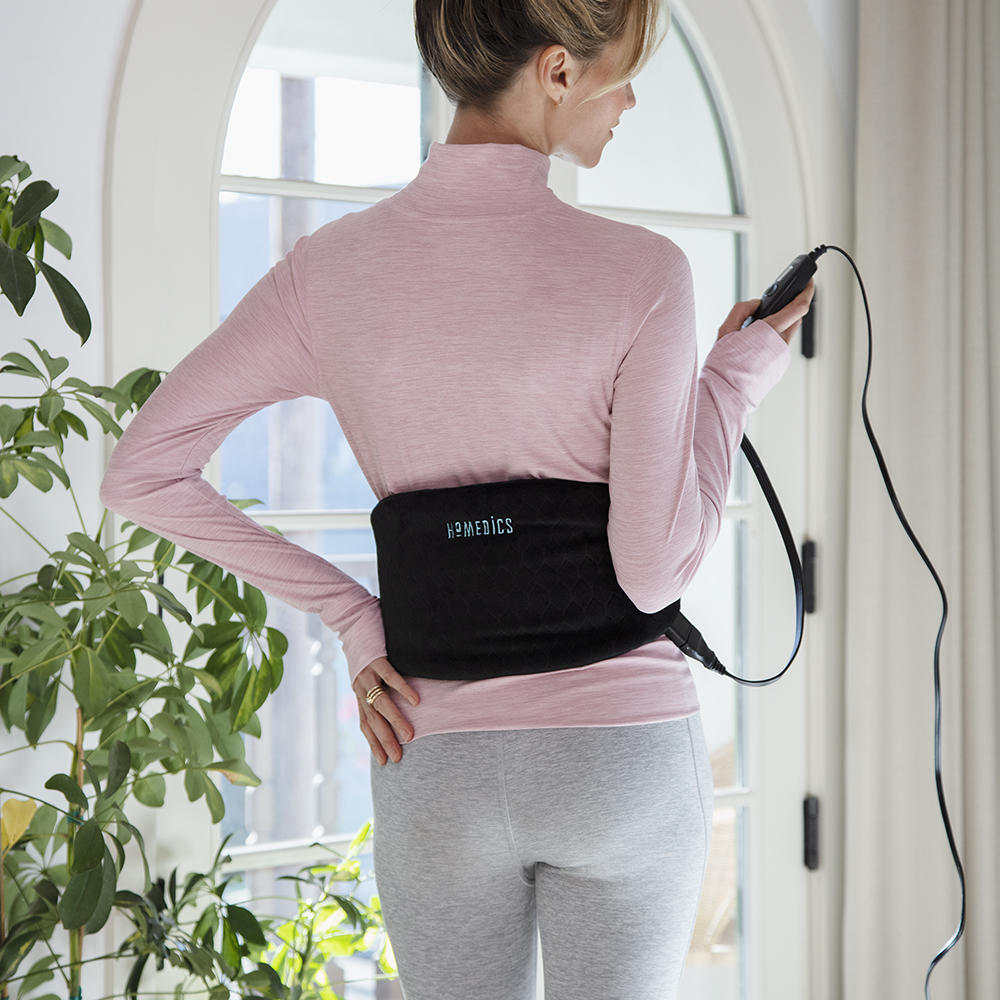 Back view of woman looking at LCD controller while wearing the Homedics Gel Belt