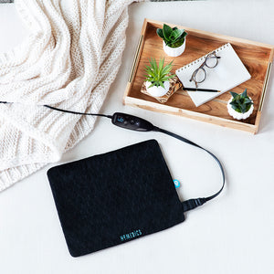 Top-down view of the Homedics Weighted Hot & Cold Gel Heating Pad sitting next to a tray and blanket