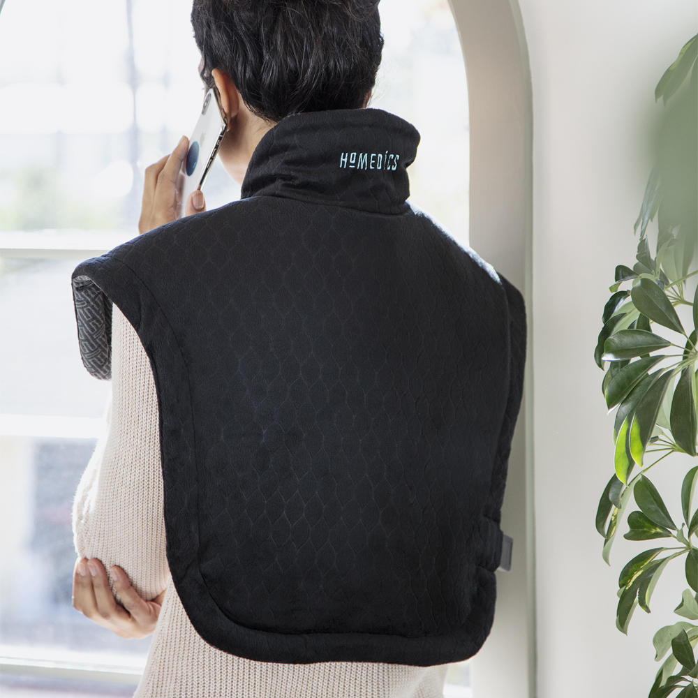 Alternate back view of woman talking on phone while wearing the Homedics Weighted Gel Back Wrap