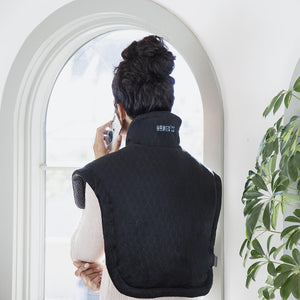 Back view of woman talking on phone while wearing the Homedics Weighted Gel Back Wrap
