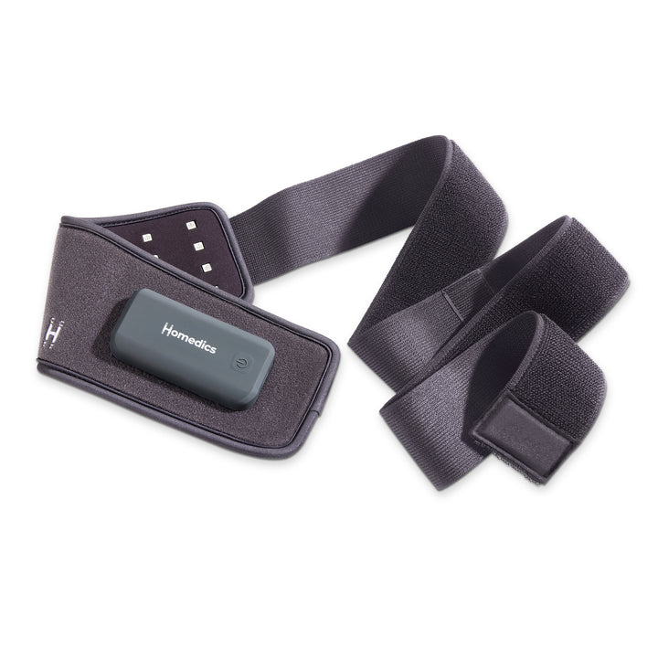 Homedics® Infrared + Red Light Pain Therapy Wrap is worn on the stomach to improve circulation while she reclines and listens to music on the couch