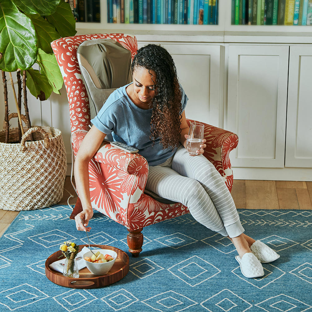 Woman sitting in large chair enjoying a massage from the Homedics Shiatsu Elite Pro Massage Cushion with Heat