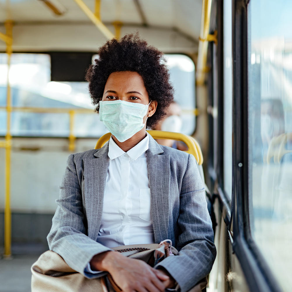 Man sits in bus while wearing the Homedics Single Use Ear-Loop Face Mask (10 Count)