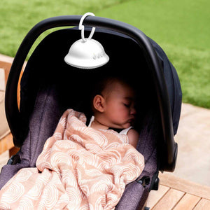 Alternate angle of baby in baby carrier sleeping with Homedics SoundSpa On-The-Go attached