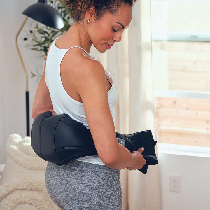 Woman enjoys lower back massage from the Homedics Shiatsu Neck and Body Massager with Heat