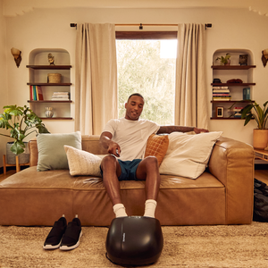 Man on couch using the 3-in-1 Pro Foot Massager with Heat