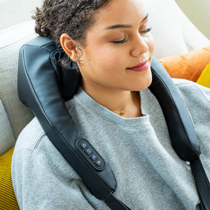 Woman reclines while wearing the Homedics Cordless Neck and Shoulder Massager with Heat