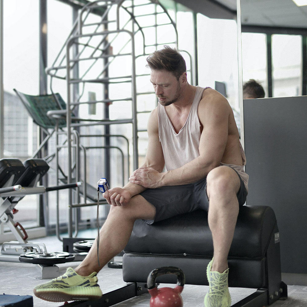 Man checks his pulse using the Homedics Pulse Oximeter during workout