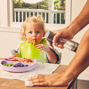 Man holds grey Homedics Ozone Clean Multipurpose Cleaner next to messy eating child
