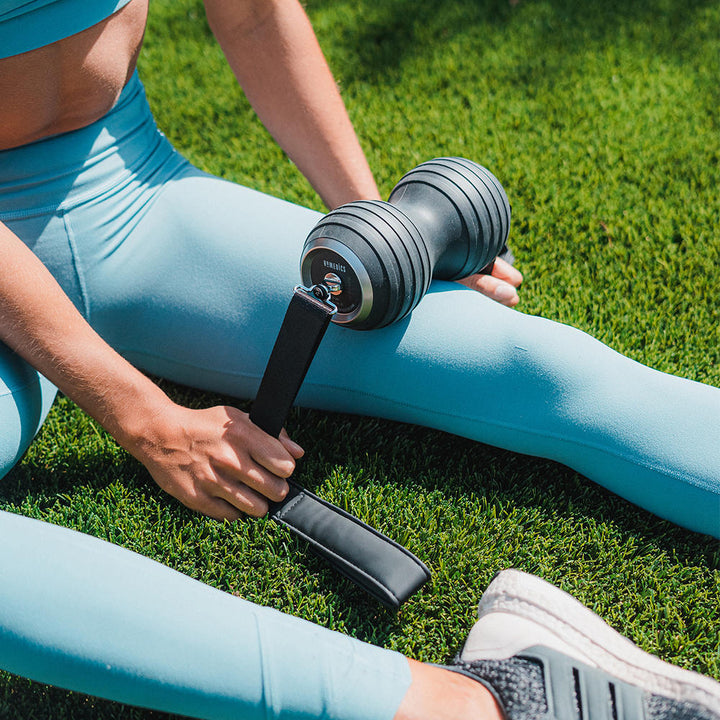 Woman massages left thigh with the Homedics Double-Barrel Total Body Massager