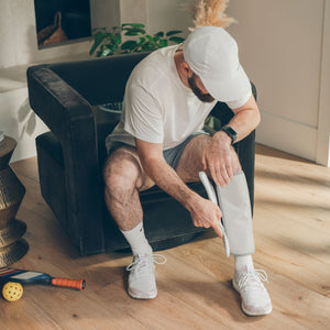Man adjusting his Homedics® Modulair Compression Calf Wrap