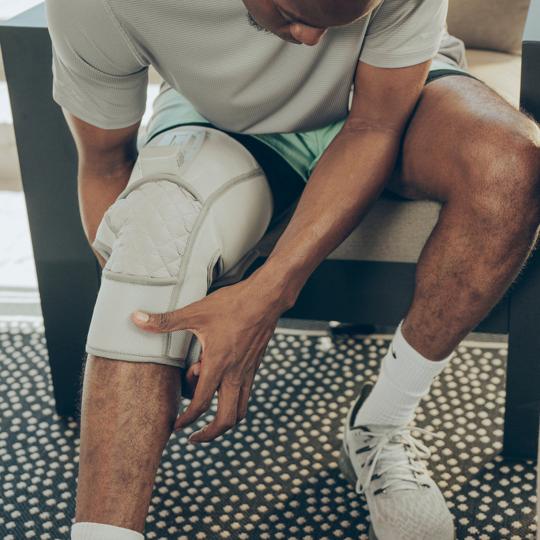 Close up view of a man setting up his Homedics® Modulair compression knee wrap.
