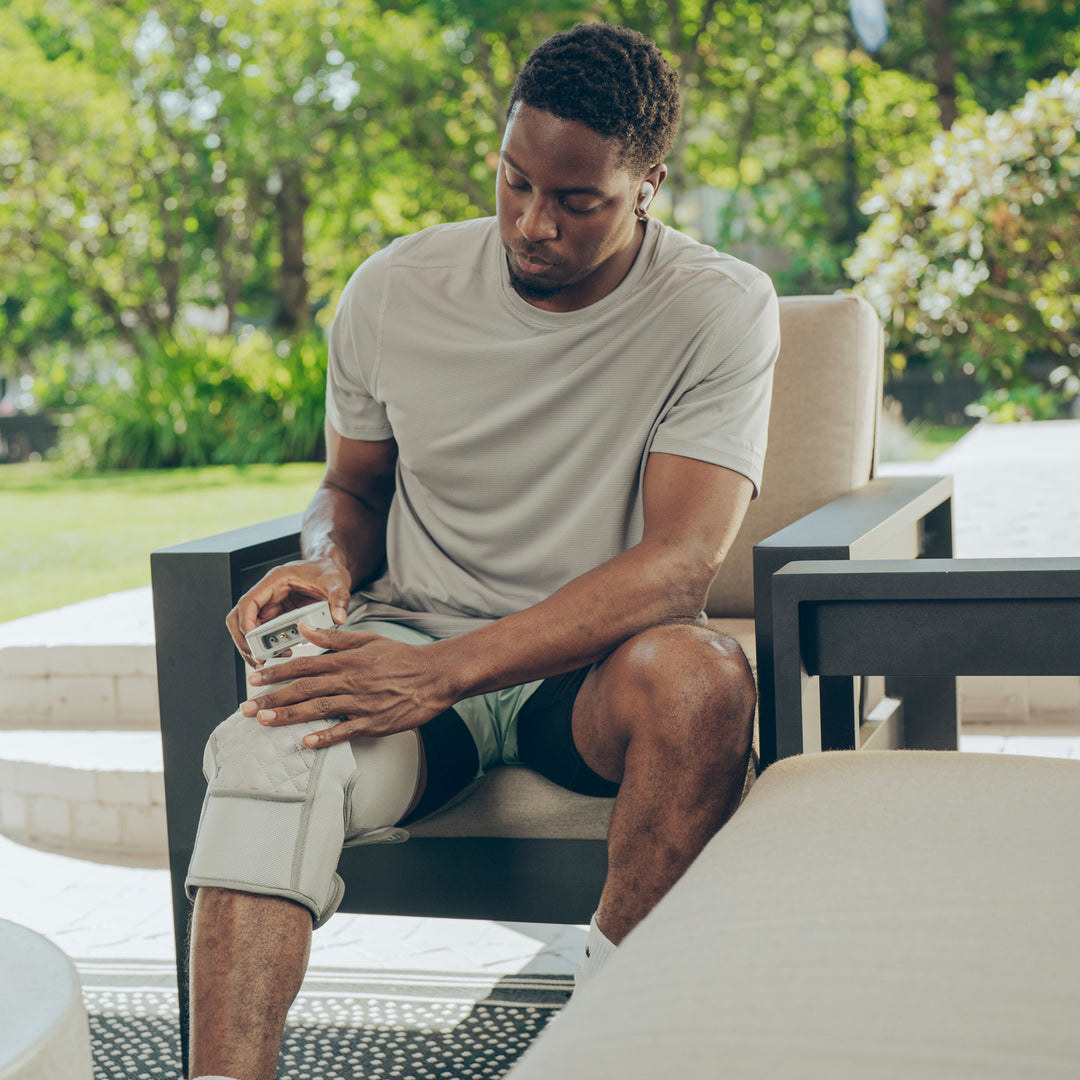 Close up view of a man using the control on the  Homedics® Modulair compression knee wrap.