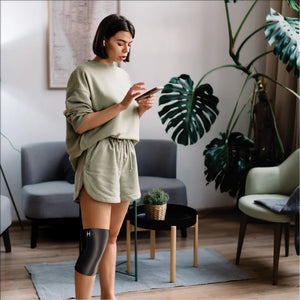A woman using the Homedics Hot and Cold Relief Gel Knee Sleeve while at leisure