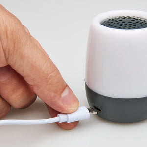 Hand inserts USB power cable into the Homedics SoundSpa Traveler White Noise Sound Machine