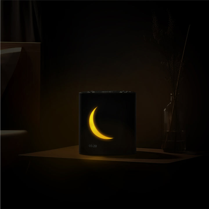 Night image of Sound Sleep Moon Dream Sound Machine & Clock displaying time and lunar visuals on display screen.